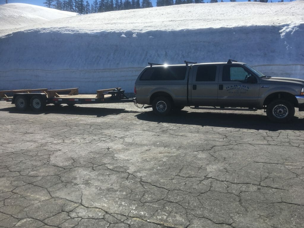 Truck parked at Bear Valley with snow behind.