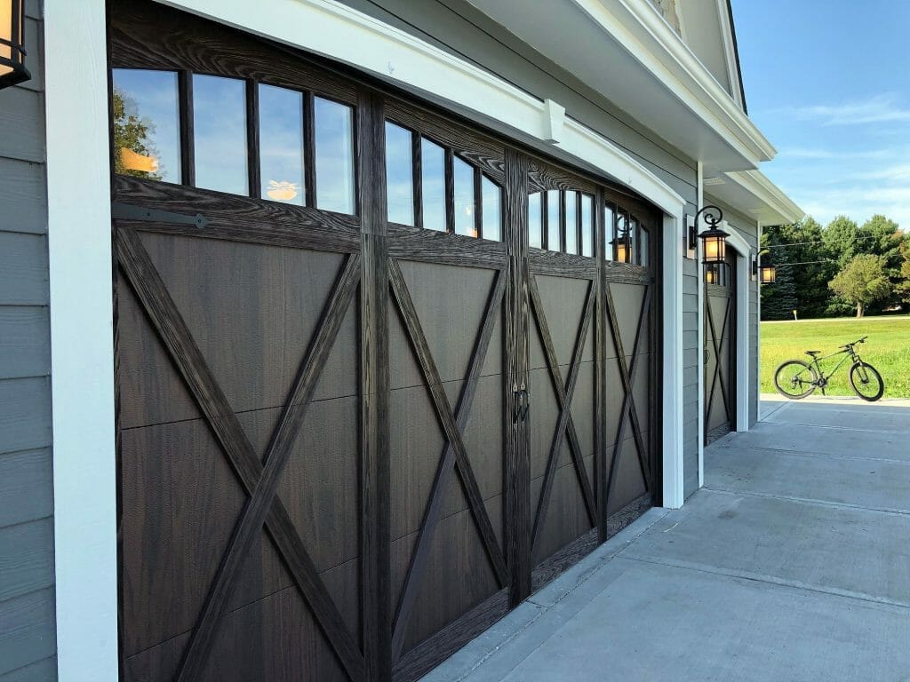 Wood overlay garage doors installed in a garage.