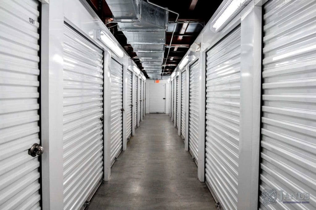 A hallway of white storage closets, each with a door.