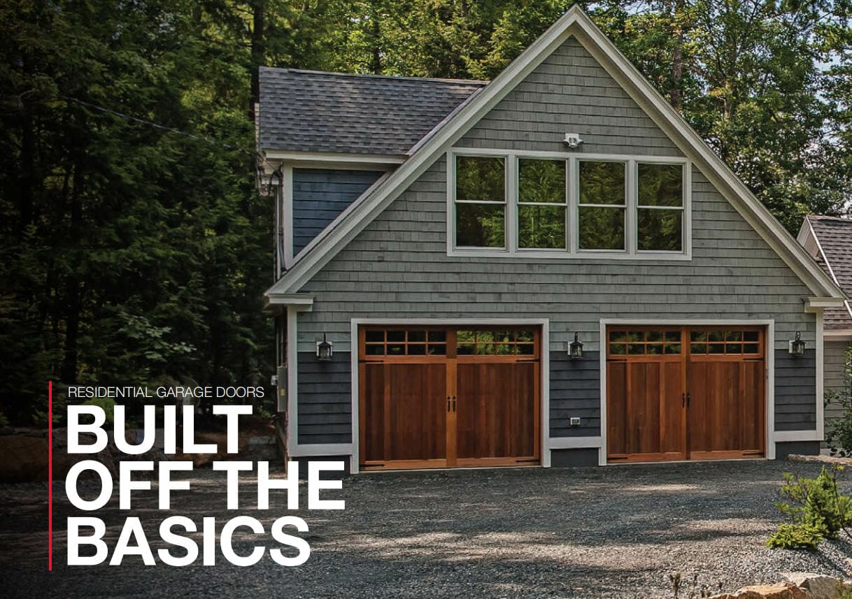 This is a snapshot of a house surrounded by trees with really nice looking wood overlay garage doors. Text in the foreground says, "Built off the basics."