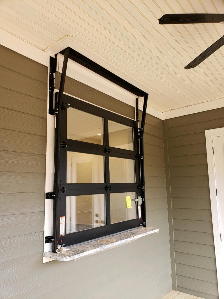 A small glass garage door installed in a window.